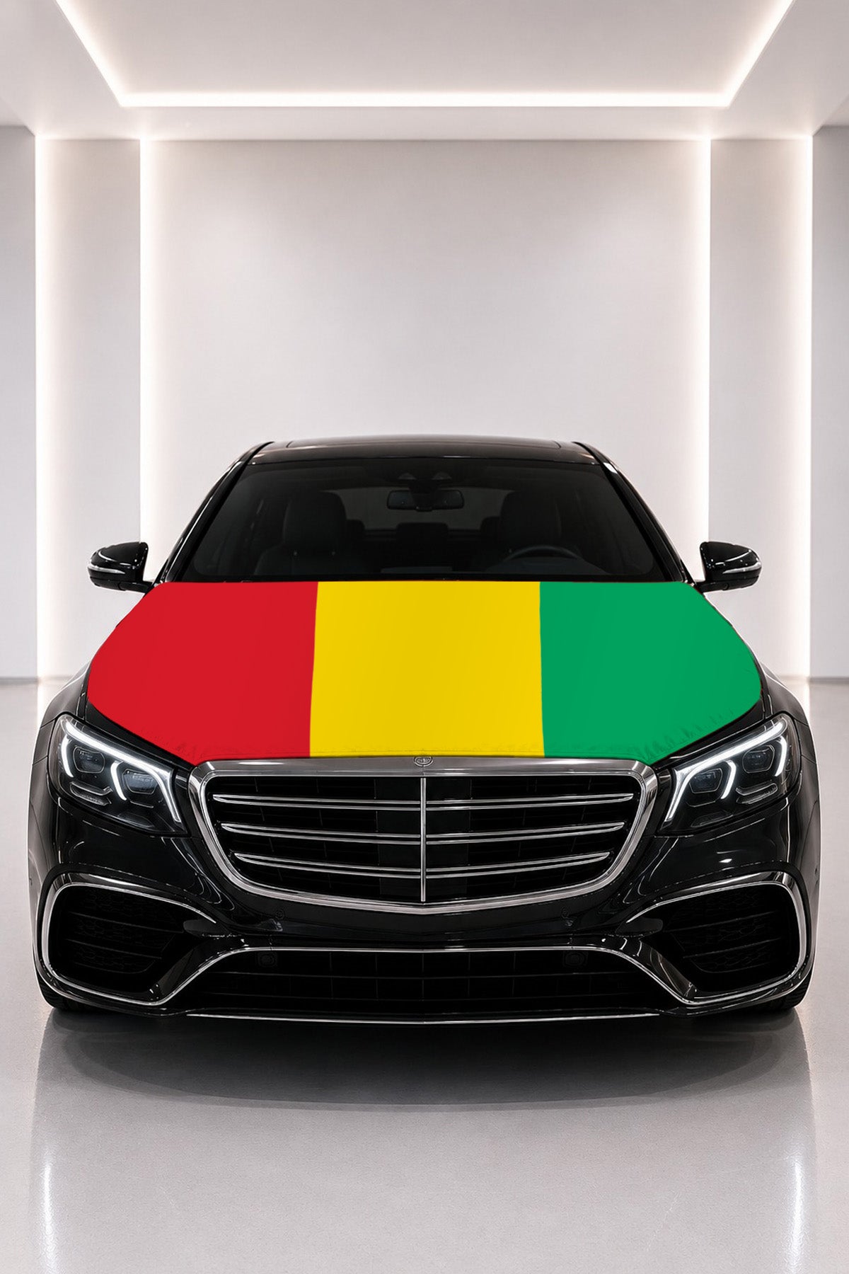 Couvre-capot drapeau de la Guinée posé sur le capot d’une voiture noire