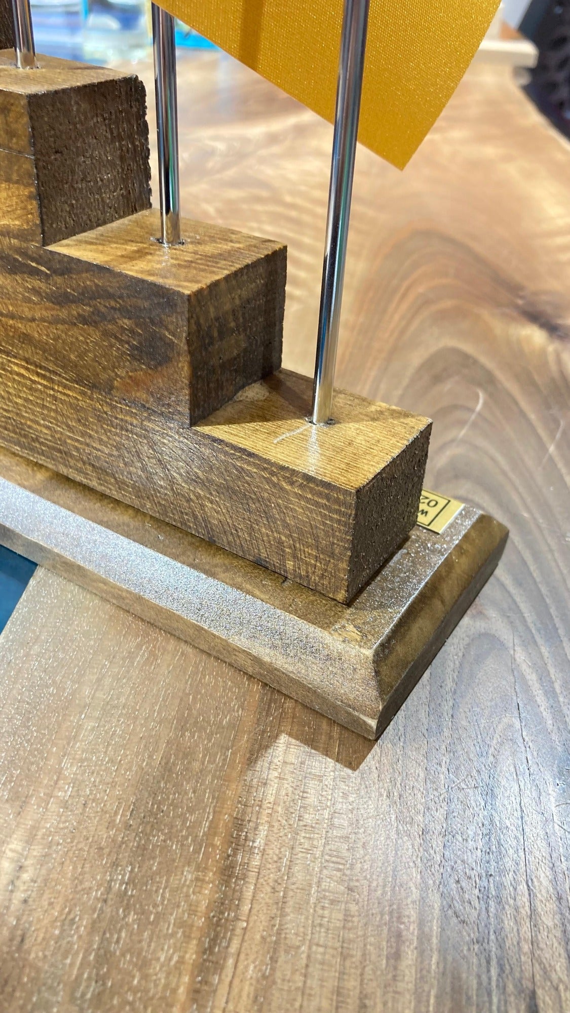 Corner detail of the hand-carved pine base showing the wood grain
