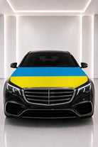 Couvre-capot drapeau de l'Ukraine posé sur le capot d’une voiture noire
