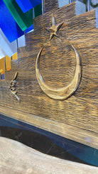 Close-up of the hand-carved crescent and star on the pine base