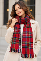 Écharpe à carreaux rouge à franges multicolores sur une femme en manteau beige