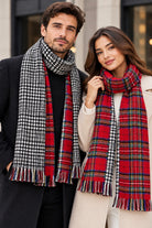 Écharpe à carreaux rouge réversible à franges portée par un homme et une femme — côté pied-de-poule et côté tartan
